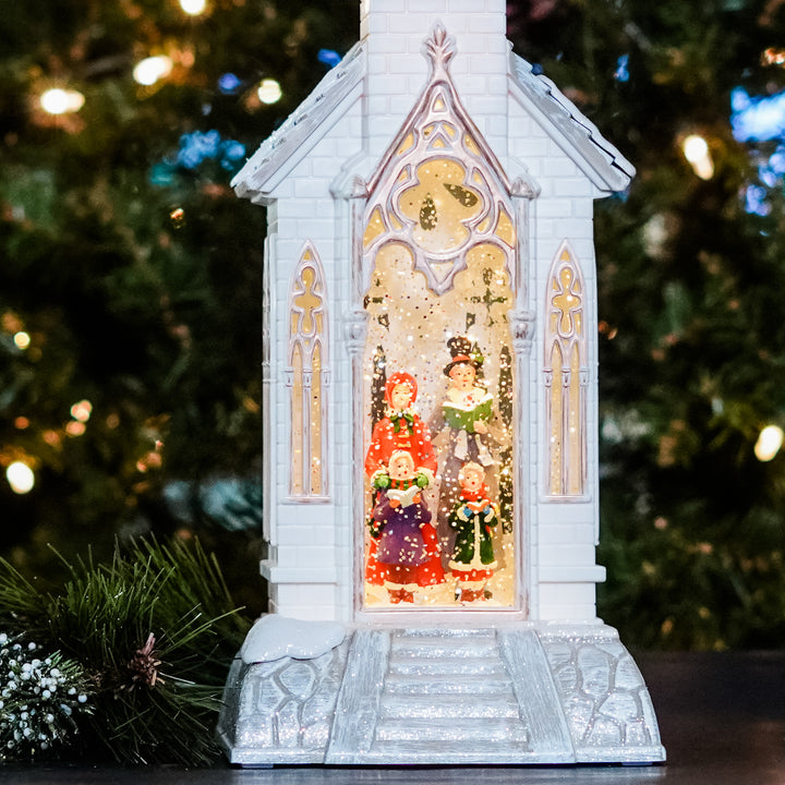 Hark the herald angles sing! Inside the church steeple, a family of carolers is nestled in swirling glitter. When turned on a warm LED light shines down on the figurines and glitter swirls to give our water lantern a whimsical look for the Holiday Season.   18 Inch Tall x 6 Inch Wide x 5.5 Inch Deep 3 Position Switch - On / Off / 6 Hour Timer 3 x AA Batteries Sold Separately Includes USB Cord. Does Not Include USB Power Adapter Continuous Swirling Glitter Snow Globe Acrylic Caroler Figurine